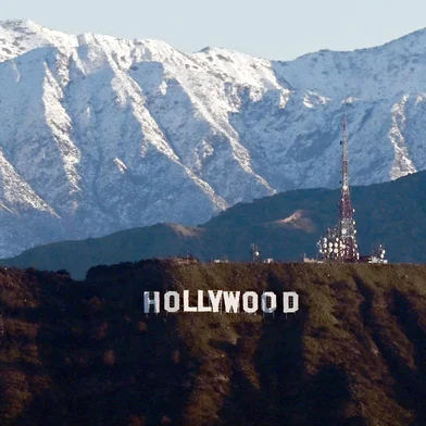 (FILES) In this file photo taken on March 02, 2023 snow capped mountains stand on the skyline behind a view of the Hollywood sign following heavy rain from winter storms, as seen from the Kenneth Hahn State Recreation Area, in Los Angeles, California. - Hollywood television and movie writers will go on strike, their union said May 1, 2023, after talks with studios and streamers on pay and other conditions ended without a deal. (Photo by Patrick T. Fallon / AFP)Editoria: ACELocal: Los AngelesIndexador: PATRICK T. FALLONSecao: cinema industryFonte: AFPFotógrafo: STF<!-- NICAID(15417481) -->