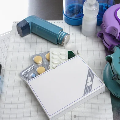 Asthma, allergie, illness relief concept, salbutamol inhalers, aerosol medication, drugs and paper on chrome background<!-- NICAID(16059347) -->