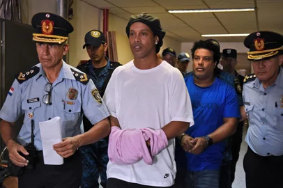 Brazilian retired football player Ronaldinho (C) and his brother Roberto Assis (R) arrive at Asuncion's Justice Palace to appear before a public prosecutor who will decide whether to grant them bail or not following their irregular entry to the country, in Asuncion, on March 7, 2020. - Former Brazilian football star Ronaldinho and his brother have been detained in Paraguay after allegedly using fake passports to enter the South American country, authorities said Wednesday. (Photo by Norberto DUARTE / AFP)Editoria: CLJLocal: AsuncionIndexador: NORBERTO DUARTESecao: soccerFonte: AFPFotógrafo: STR<!-- NICAID(14443850) -->