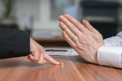 Divorce concept. Wife is returning ring to her disappointed husband who diagree and is begging for forgiveness.<!-- NICAID(15914752) -->