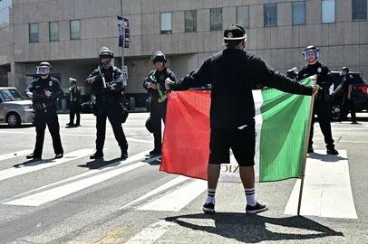 A man holds a Mexican flag outside the Metropolitan Detention Center, MDC, during a protest following federal immigration operations, in downtown Los Angeles, California on June 8, 2025. US President Donald Trump deployed 2,000 troops on June 7 to handle escalating protests against immigration enforcement raids in the Los Angeles area, a move the state's governor termed "purposefully inflammatory." Federal agents clashed with angry crowds in a Los Angeles suburb as protests stretched into a second night Saturday, shooting flash-bang grenades and shutting part of a freeway amid raids on undocumented migrants, reports said. (Photo by Frederic J. Brown / AFP)<!-- NICAID(16055278) -->