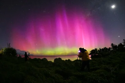 A man looks at the Aurora Australis, also known as the Southern Lights, as it glows on the horizon over the waters of Lake Ellesmere on the outskirts of Christchurch on October 8, 2024. (Photo by Sanka Vidanagama / AFP)Editoria: SCILocal: ChristchurchIndexador: SANKA VIDANAGAMASecao: natureFonte: AFPFotógrafo: STF<!-- NICAID(15885974) -->