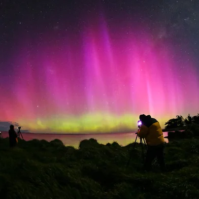 A man looks at the Aurora Australis, also known as the Southern Lights, as it glows on the horizon over the waters of Lake Ellesmere on the outskirts of Christchurch on October 8, 2024. (Photo by Sanka Vidanagama / AFP)Editoria: SCILocal: ChristchurchIndexador: SANKA VIDANAGAMASecao: natureFonte: AFPFotógrafo: STF<!-- NICAID(15885974) -->