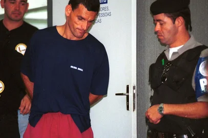 Paulo Sérgio Guimarães da Silva, o Titica, também conhecido como o Maníaco do Cassino, sendo conduzido por policiais após o seu julgamento.#PÁGINA:56FD#EDIÇÃO: 2ª Fonte: Especial ZH Data Evento: 00/02/2002<!-- NICAID(833521) -->