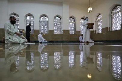 Muslim devotees maintain social distancing as they pray on the first Friday of the holy fasting month of Ramadan at a mosque in Dubai on April 16, 2021. (Photo by Karim SAHIB / AFP)<!-- NICAID(14761470) -->