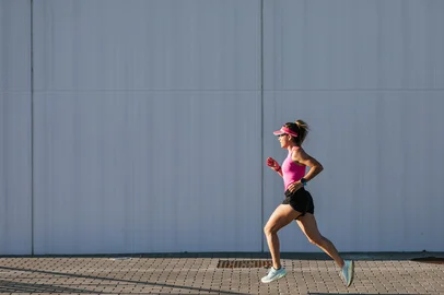 Sporty woman running in the street. Pink clothes and cap.Indexador: FÃ©lix VÃ©lezFonte: 564614004<!-- NICAID(15922637) -->