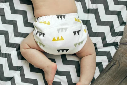 Baby boy in Eco cloth diaper on children's rug. Zero waste, eco-friendly concept. Top viewPORTO ALEGRE, RS, BRASIL, 08-09-2025: Fralda. Foto: Anikonaann/stock.adobe.comFonte: 378259143<!-- NICAID(16119895) -->