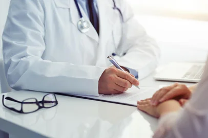 Doctor consults with his patient and writes notes on the clipboard - Photo: Rostislav Sedlacek/stock.adobe.comFonte: 181517362<!-- NICAID(15072946) -->