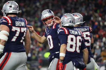 FOXBOROUGH, MASSACHUSETTS - JANUARY 04: Drake Maye #10 of the New England Patriots celebrates with teammates after a touchdown pass to Rhamondre Stevenson #38 of the New England Patriots (not pictured) in the third quarter against the Miami Dolphins at Gillette Stadium on January 04, 2026 in Foxborough, Massachusetts.   Sarah Stier/Getty Images/AFP (Photo by Sarah Stier / GETTY IMAGES NORTH AMERICA / Getty Images via AFP)<!-- NICAID(16199293) -->