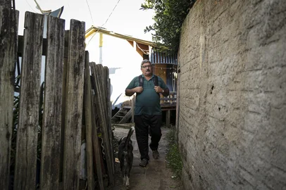 Porto Alegre, RS, Brasil, 08-05-2023: O padre Rudimar DalAsta, 52 anos, em um dos becos da ilha. Moradores da Ilha Maua vivem em area com possibilidade de alagamento no bairro Arquipelago. O numero de areas consideradas de risco para desastre natural em Porto Alegre aumentou 19% nos ultimos dez anos, segundo relatorio divulgado pela prefeitura. Foto: Mateus Bruxel / Agencia RBSIndexador: Andre Avila<!-- NICAID(15423542) -->