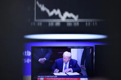 A tv-screen displaying US-President Donald Trump is pictured at the stock exchange in Frankfurt am Main, western Germany, on August 1, 2025, as in background can be seen the chart of Germany's share index DAX. Stock markets fell as Donald Trump announced tariffs on dozens of trading partners ahead of a self-imposed deadline, offsetting strong earnings from tech giants. (Photo by Daniel ROLAND / AFP)Editoria: FINLocal: FrankfurtIndexador: DANIEL ROLANDSecao: macro economicsFonte: AFPFotógrafo: STR<!-- NICAID(16093007) -->