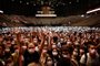 People raise their hands before the start of a test concert of French rock band Indochine and French DJ Etienne de Crecy, aimed to investigate how such events can take place safely amidst the Covid-19 pandemic at the AccorHotels Arena in Paris on May 29, 2021. (Photo by STEPHANE DE SAKUTIN / AFP)<!-- NICAID(14795918) -->
