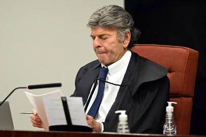Brazil's Federal Supreme Court (STF) minister Luiz Fux reads a document during the voting session to convict or acquit far-right Brazil's former President (2019-2022) Jair Bolsonaro in a coup trial at the Federal Supreme Court (STF) in Brasilia on September 11, 2025. A Brazilian judge on September 10 returned the first not-guilty vote in the coup-plotting trial of former president Jair Bolsonaro, shifting all eyes on the last two of his colleagues left to vote following two guilty findings. (Photo by EVARISTO SA / AFP)Editoria: POLLocal: BrasíliaIndexador: EVARISTO SASecao: trialsFonte: AFPFotógrafo: STF<!-- NICAID(16122205) -->