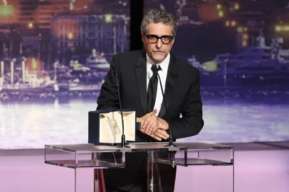Brazilian director Kleber Mendonca Filho accepts the Best Actor Prize on behalf of Brazilian actor Wagner Moura for the film "O Agente Secreto" (The Secret Agent) during the Closing Ceremony at the 78th edition of the Cannes Film Festival in Cannes, southern , on May 24, 2025. (Photo by Sameer AL-DOUMY / AFP)<!-- NICAID(16045221) -->