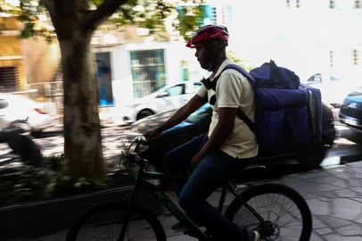 PORTO ALEGRE, RS, BRASIL, 04-11-2025: Trabalhador informal Cleyton de Oliveira aposta em venda de doces e agua em sinaleira e entregas de aplicativos de alimentação para garantir renda mensal. Foto: Jonathan Heckler/Agência RBS<!-- NICAID(16160253) -->