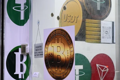 Peter PARKS / AFP The symbols of bitcoin and the stablecoin Tether (USDT) are displayed at a cryptocurrency store in Hong Kong on July 29, 2025. Stablecoin excitement has gripped Hong Kong as the city prepares to launch a licensing system for the less volatile type of cryptocurrency, but authorities warn against overplaying its future role in financial systems. (Photo by Peter PARKS / AFP) / To go with AFP story Hong Kong-China-cryptocurrency-banking-tech, FOCUS by Holmes Chan, with Katie Forster in TokyoEditoria: FINLocal: Hong KongIndexador: PETER PARKSSecao: currency valuesFonte: AFPFotógrafo: STF<!-- NICAID(16163008) -->