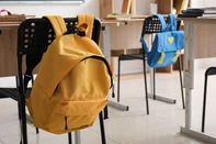 Schoolbag hanging on chair in classroom, closeup<!-- NICAID(16206467) -->