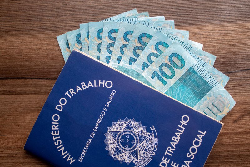 Brazilian document work and social security ( Carteira de Trabalho e Previdencia Social) with brazilian moneyBrazilian document work and social security ( Carteira de Trabalho e Previdencia Social) with brazilian moneyIndexador: @rpcast_photoFonte: 248078883<!-- NICAID(14636836) -->