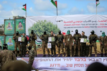 Palestinian Hamas militants parade three newly-released Israeli hostages on stage in Nuseirat in the central Gaza Strip, as part of the seventh hostage-prisoner release on February 22, 2025. (Photo by Eyad BABA / AFP)<!-- NICAID(15981795) -->