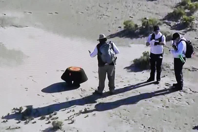 This shot off a NASA live feed shows NASA safety team members prepare the Osiris-Rex asteroid sample return craft sitting in the Utah desert at Dugway, Utah, on September 24, 2023. The largest sample ever collected from an asteroid in space, and the first for NASA, landed in the Utah desert Sunday after a fiery final descent through Earth's atmosphere, seven years after the mission's launch. Scientists hope the asteroid sample aboard the spacecraft will provide humanity with a better understanding on the formation of our solar system and how Earth became habitable. (Photo by Handout / NASA / AFP) / RESTRICTED TO EDITORIAL USE - MANDATORY CREDIT "AFP PHOTO /  NASA " - NO MARKETING NO ADVERTISING CAMPAIGNS - DISTRIBUTED AS A SERVICE TO CLIENTSEditoria: SCILocal: DugwayIndexador: HANDOUTSecao: space programmeFonte: NASAFotógrafo: Handout<!-- NICAID(15549627) -->