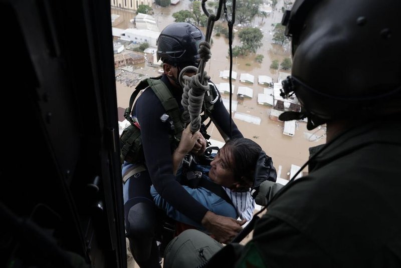 CANOAS, RS, Brasil, 04-05-2024: Pessoas resgatadas por equipe de bombeiros e exército de cima dos telhados das casas alagadas no bairro Rio Branco, em Canoas. Sete resgatados foram levados para o hospital da Ulbra. Foto: Mateus Bruxel / Agência RBS<!-- NICAID(15754369) -->