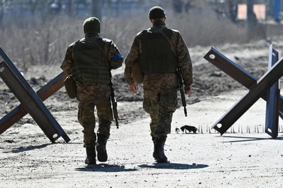 Ukrainian soldiers walk on the front line, near Kyiv on March 20, 2022. (Photo by Genya SAVILOV / AFP)<!-- NICAID(15050127) -->