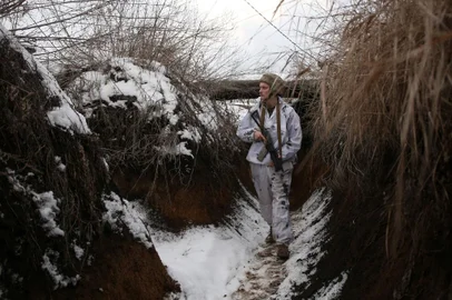 Um soldado ucraniano caminha ao longo de uma trincheira coberta de neve na linha de frente com os separatistas apoiados pela Rússia perto da vila de Verkhnetoretskoye, na região de Donetsk, em 31 de janeiro de 2022. (Foto de Anatolii STEPANOV / AFP)<!-- NICAID(15003219) -->