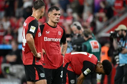 Bayer Leverkusen's Swiss midfielder #34 Granit Xhaka (C) and his teammates react after the German first division Bundesliga football match between Bayer 04 Leverkusen and RB Leipzig in Leverkusen, southwestern Germany on August 31, 2024. (Photo by UWE KRAFT / AFP) / DFL REGULATIONS PROHIBIT ANY USE OF PHOTOGRAPHS AS IMAGE SEQUENCES AND/OR QUASI-VIDEO<!-- NICAID(15855185) -->