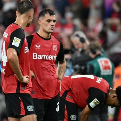 Bayer Leverkusen's Swiss midfielder #34 Granit Xhaka (C) and his teammates react after the German first division Bundesliga football match between Bayer 04 Leverkusen and RB Leipzig in Leverkusen, southwestern Germany on August 31, 2024. (Photo by UWE KRAFT / AFP) / DFL REGULATIONS PROHIBIT ANY USE OF PHOTOGRAPHS AS IMAGE SEQUENCES AND/OR QUASI-VIDEO<!-- NICAID(15855185) -->