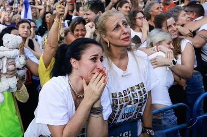 People celebrate at Hostage Square in Tel Aviv as news came out that a Red Cross convoy is on its way to pick up a second group of Israeli hostages to be freed by Hamas on October 13, 2025. A Red Cross convoy is on its way to pick up a second group of Israeli hostages to be freed by Hamas as part of a Gaza ceasefire deal October 13, the Israeli military said. An army statement said the handover would take place at "an additional meeting point in the southern Gaza Strip, where several hostages will be handed over to the Red Cross." (Photo by Menahem Kahana / AFP)<!-- NICAID(16144634) -->