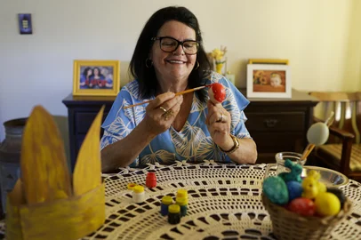 SÃO LEOPOLDO, RS, BRASIL, 31-03-2026: A aposentada Janete Timm, 66, pinta ovos para seguir uma tradição de família, em casa, em São Leopoldo. Em seguida, ela recheia os ovos com amendoim e esconde pela casa para que os netos e netas encontrem no domingo de Páscoa. Foto: Mateus Bruxel/Agência RBSIndexador: MATEUS BRUXEL<!-- NICAID(16255716) -->