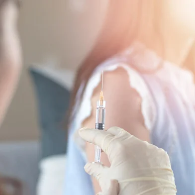World immunization week and International HPV awareness day concept. Woman having vaccination for influenza or flu shot or HPV prevention with syringe by nurse or medical officer.Fonte: 222787795<!-- NICAID(14894187) -->
