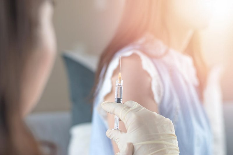 World immunization week and International HPV awareness day concept. Woman having vaccination for influenza or flu shot or HPV prevention with syringe by nurse or medical officer.Fonte: 222787795<!-- NICAID(14894187) -->