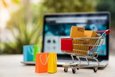 Product package boxes in cart with shopping bag and laptop computer with blurred web store shop on screen for online shopping and delivery conceptFonte: 407233108<!-- NICAID(15429515) -->