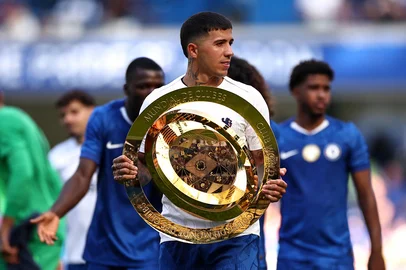 Chelsea's Argentinian midfielder #08 Enzo Fernandez carries the Club World Cup trophy following the pre-season friendly football match between Chelsea and AC Milan at Stamford Bridge in London on August 10, 2025. (Photo by HENRY NICHOLLS / AFP)<!-- NICAID(16101288) -->