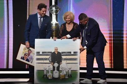 Argentina's Football Association (AFA) president Claudio Tapia (R), Conmebol's president Paraguayan Alejandro Dominguez (L), and Dominguez's mother, Peggy Wilson-Smith, take part in a tribute to Dominguez's father, Osvaldo Dominguez, during the Copa Libertadores and Copa Sudamericana draw at Conmebol's headquarters in Luque, Paraguay, on March 18, 2024. (Photo by NORBERTO DUARTE / AFP)<!-- NICAID(15709443) -->