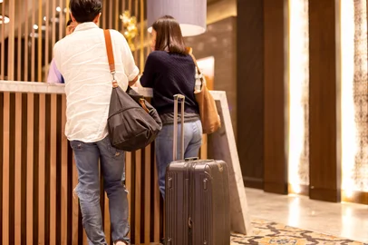 Asian couple with suitcase checking in at hotel reception.Asian couple with suitcase checking in at hotel receptionFonte: 241929448<!-- NICAID(16187786) -->