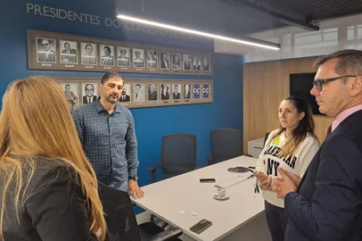 Presidente da CIC, Celestino Loro, com Marcio Amaral, da campanha de Adiló Didomenico, e Virgínia Boff, da campanha de Maurício Scalco, durante sorteio de reunião-almoço em que os candidatos irão participar. Foi na manhã desta segunda-feira (7). <!-- NICAID(15885148) -->