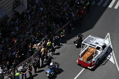 People gather along the road as the coffin of late Pope Francis is transported from St Peter's Basilica to Santa Maria Maggiore Basilica during the funeral ceremony in Rome on April 26, 2025. (Photo by Piero CRUCIATTI / AFP)<!-- NICAID(16024978) -->