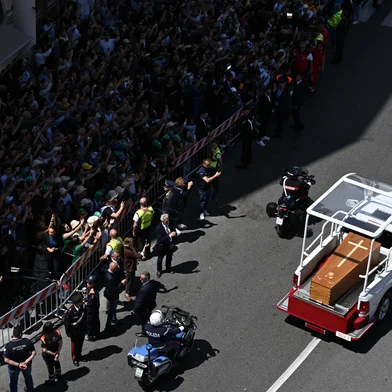 People gather along the road as the coffin of late Pope Francis is transported from St Peter's Basilica to Santa Maria Maggiore Basilica during the funeral ceremony in Rome on April 26, 2025. (Photo by Piero CRUCIATTI / AFP)<!-- NICAID(16024978) -->