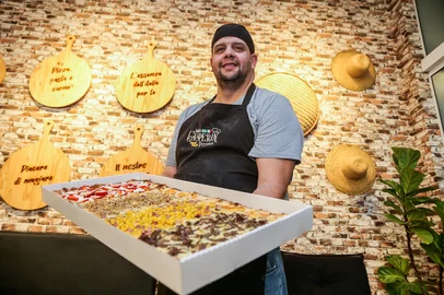 FARROUPILHA, RS, BRASIL, 22/07/2026. Fabiano Gasparin, 45, decidiu criar a pizza trem, de 75cm x 35cm, para conquistar os grandes grupos de amigos e familiares de Farroupilha. A pizza trem, de 75cm x 35cm,  foi criada em 2020 por Fabiano Gasparin, da Pizzaria Família Gasparin, em Farroupilha, e pode levar mais de 5kg de ingredientes. (Neimar De Cesero/Agência RBS)Indexador: Neimar De Cesero<!-- NICAID(16337997) -->