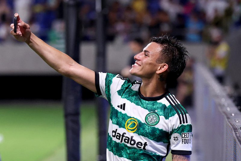 Celtic's Alexandro Bernabei takes a selfie with fans during a friendly football match between Japan's Gamba Osaka and Scotland's Celtic at Suita City Stadium in the city of Suita, Osaka prefecture on July 22, 2023. (Photo by PAUL MILLER / AFP)Editoria: SPOLocal: SuitaIndexador: PAUL MILLERSecao: sports eventFonte: AFPFotógrafo: STR<!-- NICAID(15698179) -->