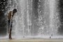 TOPSHOT - A man cools off by a fountain water during a heatwave in Seville on July 10, 2023. Temperatures were soaring across Spain on July 10 with the mercury set to touch 44 degrees Celsius (111 Fahrenheit) in the south as the country braced for its second heatwave in a fortnight. (Photo by CRISTINA QUICLER / AFP)Editoria: WEALocal: SevilleIndexador: CRISTINA QUICLERSecao: weather scienceFonte: AFPFotógrafo: STR<!-- NICAID(15479268) -->