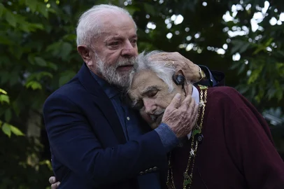 (FILES) Brazil's President Luiz Inacio Lula da Silva (L) embraces former Uruguayan President (2010-2015) Jose Mujica after decorating him with the National Order of the Southern Cross during a visit to the latter's home in Montevideo on December 5, 2024. Uruguay's former president (2010-2015) Jose "Pepe" Mujica, a former guerrilla fighter and icon of the left in Latin America, died at the age of 89 on May 13, 2025, the government announced. The farmer dubbed the "world's poorest president" during his presidency for his modest lifestyle had been diagnosed with cancer of the esophagus in May 2024. (Photo by Dante Fernandez / AFP)Editoria: POLLocal: MontevideoIndexador: DANTE FERNANDEZSecao: diplomacyFonte: AFPFotógrafo: STR<!-- NICAID(16036070) -->
