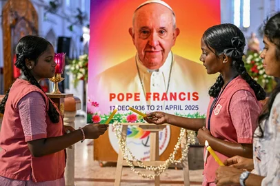 People pray in front of a portrait of Pope Francis at a Catholic church in Chennai on April 21, 2025,  following the news of his death. Pope Francis, an energetic reformer who inspired widespread devotion from Catholics but riled traditionalists, died on April 21, aged 88, just a day after greeting delighted worshippers after Easter Mass. (Photo by R. Satish BABU / AFP)Editoria: RELLocal: ChennaiIndexador: R. SATISH BABUSecao: roman catholicFonte: AFPFotógrafo: STR<!-- NICAID(16020878) -->