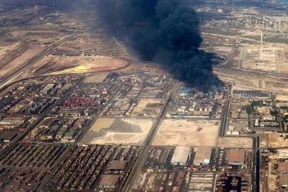 This handout picture provided by the media office of the Iranian presidency shows heavy smoke billowing at the site of an explosion that took place a day earlier at the Shahid Rajaee port dock southwest of Bandar Abbas in the Iranian province of Hormozgan on April 27, 2025. Pezeshkian visited on Sunday the scene of a massive port blast that killed 28 people and injured more than 1,000, as fires still blazed more than 24 hours after the explosion. (Photo by Iranian Presidency / AFP) / RESTRICTED TO EDITORIAL USE - MANDATORY CREDIT "AFP PHOTO / HANDOUT / IRANIAN PRESIDENCY" - NO MARKETING NO ADVERTISING CAMPAIGNS - DISTRIBUTED AS A SERVICE TO CLIENTS<!-- NICAID(16025372) -->