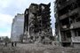 People walk in front of buildings destroyed in bombardment, in the Ukrainian town of Borodianka, in the Kyiv region on April 17, 2022. - Russia invaded Ukraine on February 24, 2022. (Photo by Sergei SUPINSKY / AFP)Editoria: WARLocal: BorodiankaIndexador: SERGEI SUPINSKYSecao: armed conflictFonte: AFPFotógrafo: STF<!-- NICAID(15071036) -->