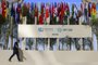 A man walks past national flags of participating countries at the venue of the COP28 United Nations climate summit in Dubai on November 30, 2023. The UN climate conference opens in Dubai on November 30 with nations under pressure to increase the urgency of action on global warming and wean off fossil fuels, amid intense scrutiny of oil-rich hosts UAE. (Photo by Karim SAHIB / AFP)Editoria: WEALocal: DubaiIndexador: KARIM SAHIBSecao: diplomacyFonte: AFPFotógrafo: STF<!-- NICAID(15612677) -->