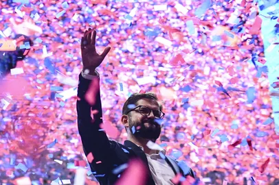 Chilean president-elect Gabriel Boric waves at supporters after delivering a speech, in Santiago, on December 19, 2021. - The streets of Santiago exploded in celebration Sunday after leftist millennial Gabriel Boric was declared Chile's new president with an unexpectedly large victory over his far-right rival in a polarizing race. Boric, 35, garnered nearly 56 percent of the vote compared to 44 percent for ultra-conservative Jose Antonio Kast, who congratulated the "president-elect" on Twitter even before the final result was known. (Photo by MARTIN BERNETTI / AFP)<!-- NICAID(14974835) -->