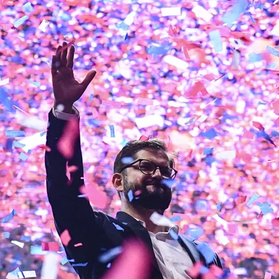 Chilean president-elect Gabriel Boric waves at supporters after delivering a speech, in Santiago, on December 19, 2021. - The streets of Santiago exploded in celebration Sunday after leftist millennial Gabriel Boric was declared Chile's new president with an unexpectedly large victory over his far-right rival in a polarizing race. Boric, 35, garnered nearly 56 percent of the vote compared to 44 percent for ultra-conservative Jose Antonio Kast, who congratulated the "president-elect" on Twitter even before the final result was known. (Photo by MARTIN BERNETTI / AFP)<!-- NICAID(14974835) -->